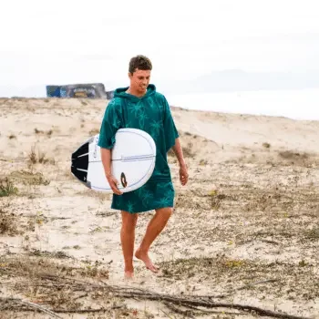 Your surf poncho - perfect beach companion Surfer dressed with surfboard & surf poncho