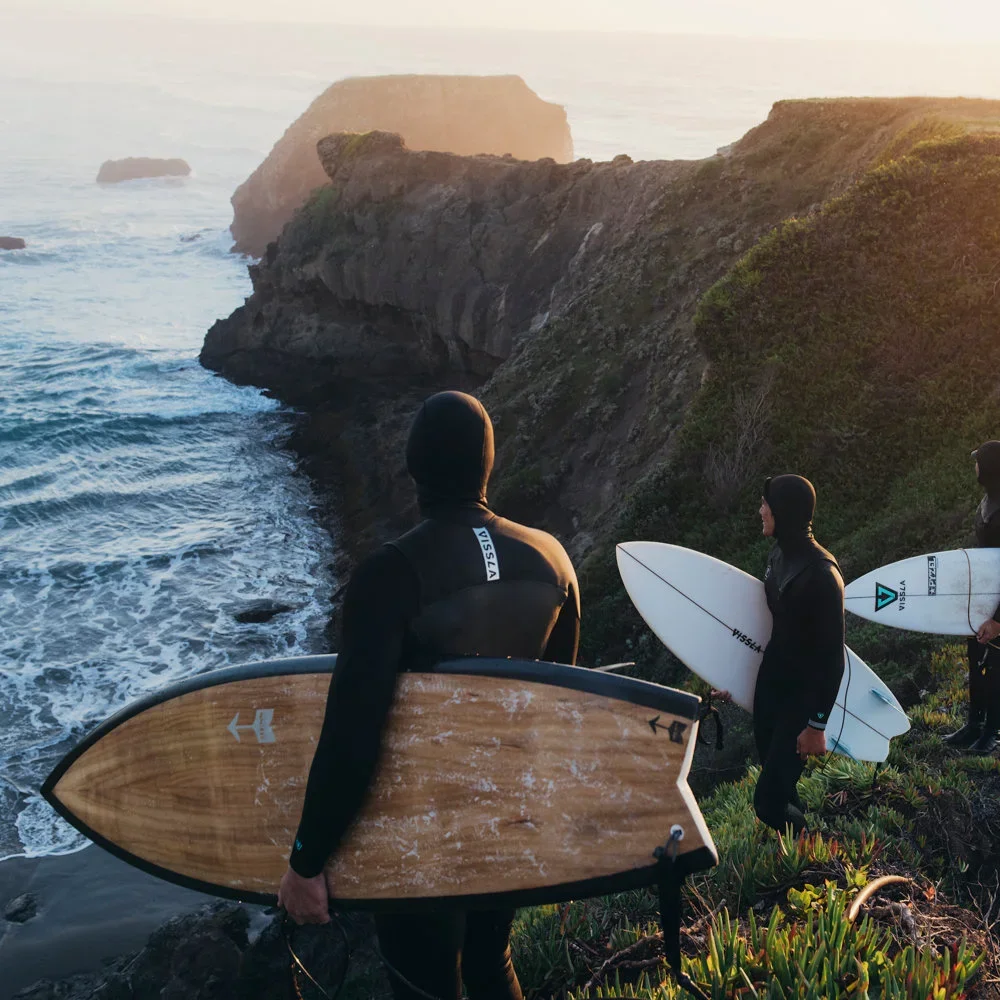Surfer with Vissla Wetsuit Neoprene anzüge auf einer Klippe bat sunndowner