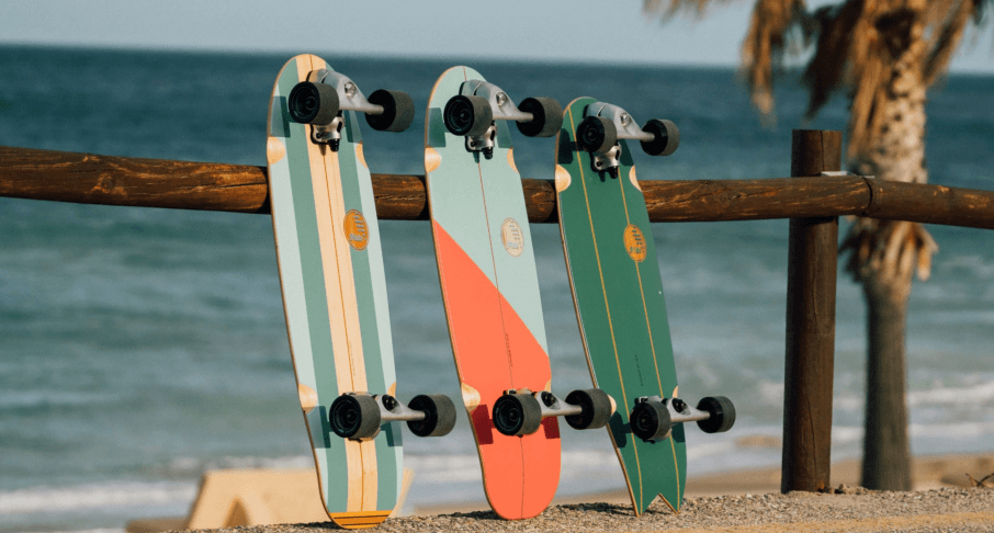 Slide Surfskates angelehnt am Zaun mit Blick aufs Meer